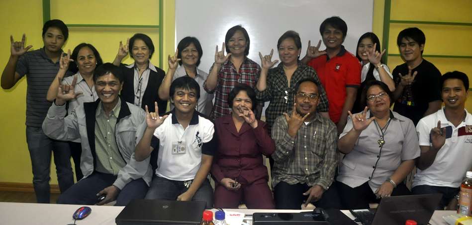 DILG and PIA participants do the "I Love you" hand sign.